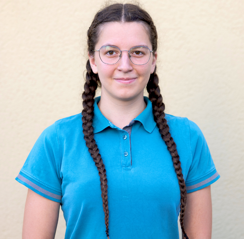 Portraitbild der Tiermedizinischen Fachangestellten Selina Voigtmann in hellblauem Kassack vor hellem Hintergrund.